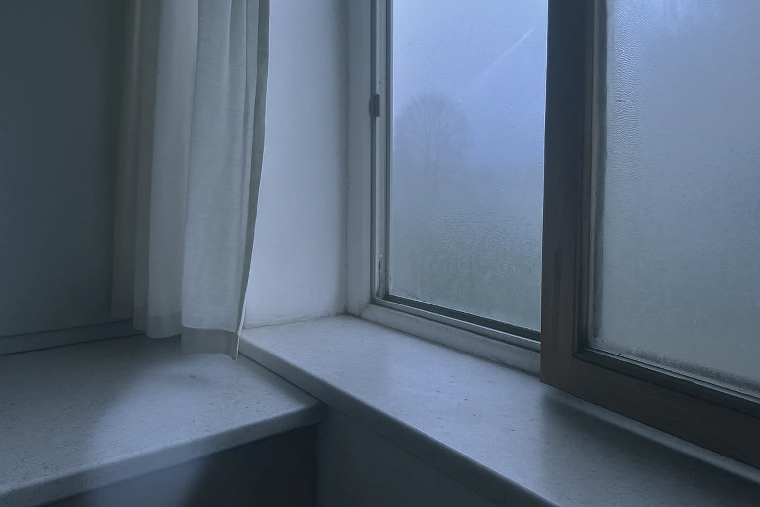 Buée de respiration sur une vitre froide au petit matin, image associée au soupir physiologique