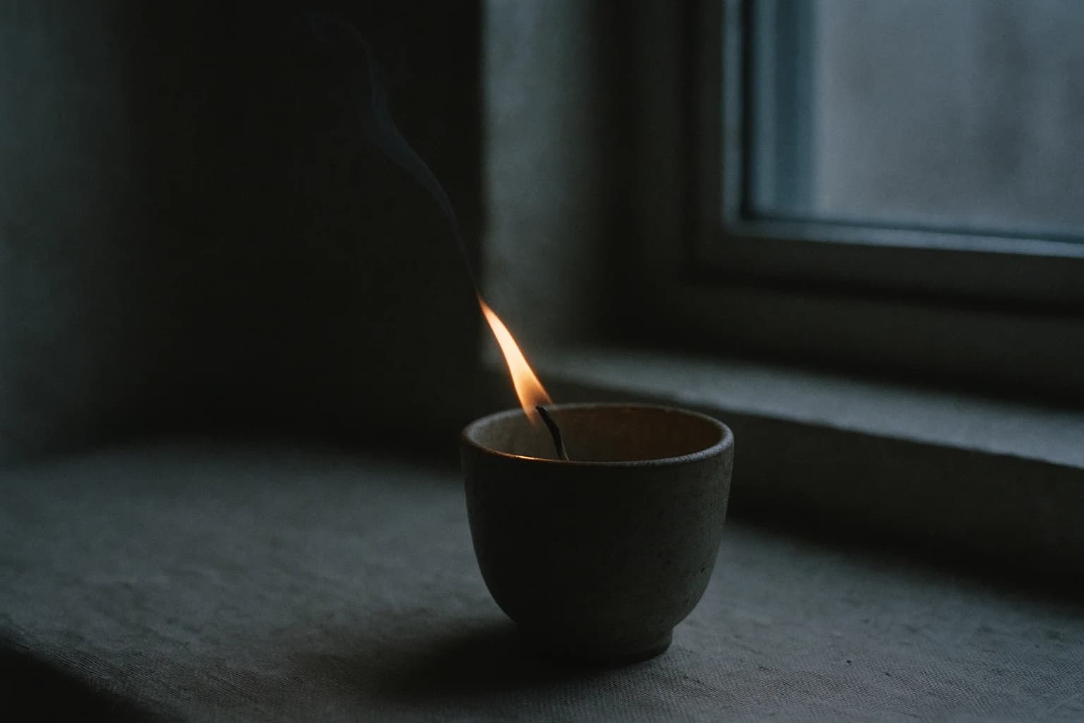 Flamme de bougie inclinée par un souffle lent, illustration de l’expiration qui accompagne un mantra pour se calmer.
